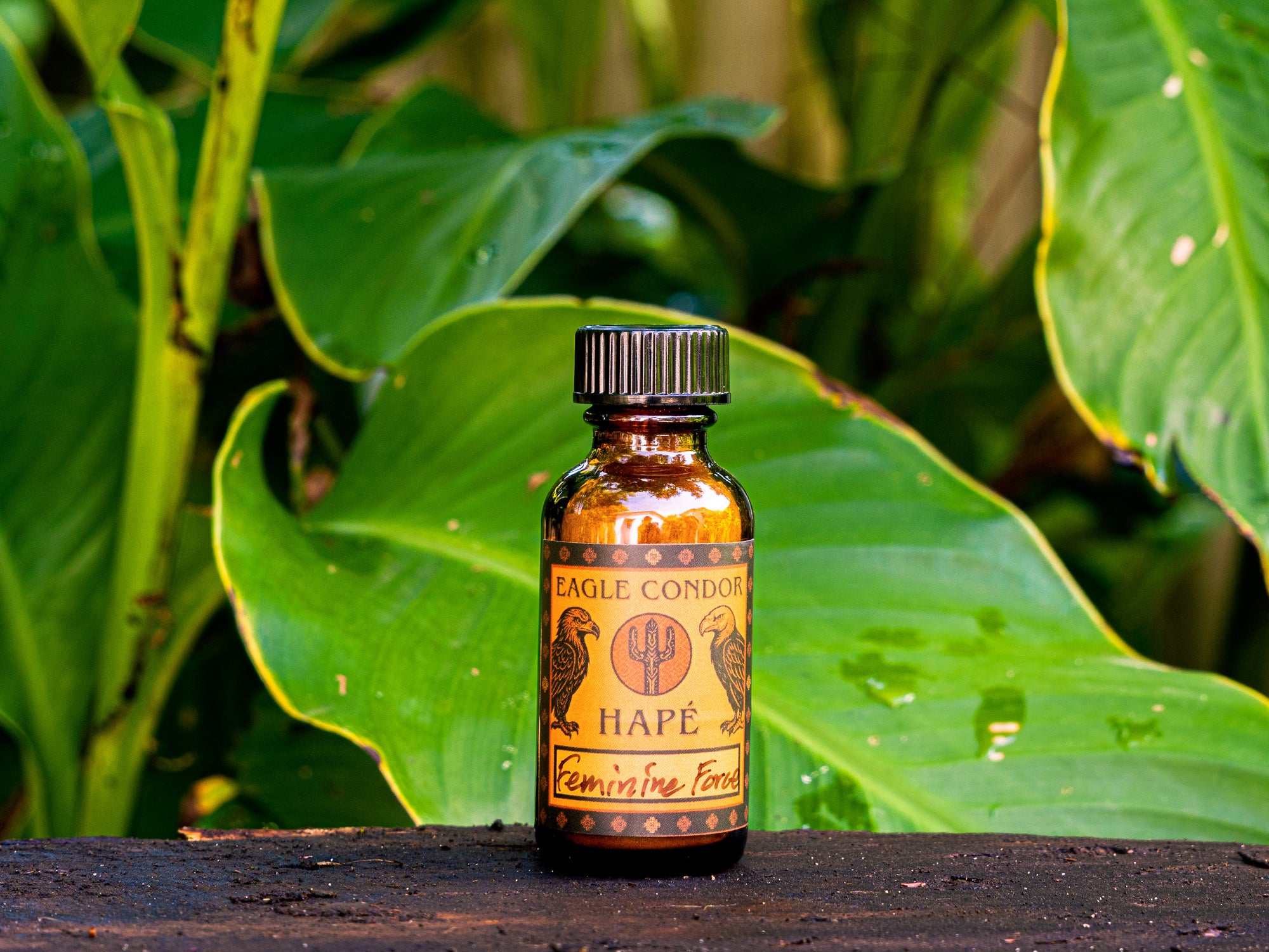 Bottle of Eagle Condor Feminine Force Hape against a natural background with green leaves.