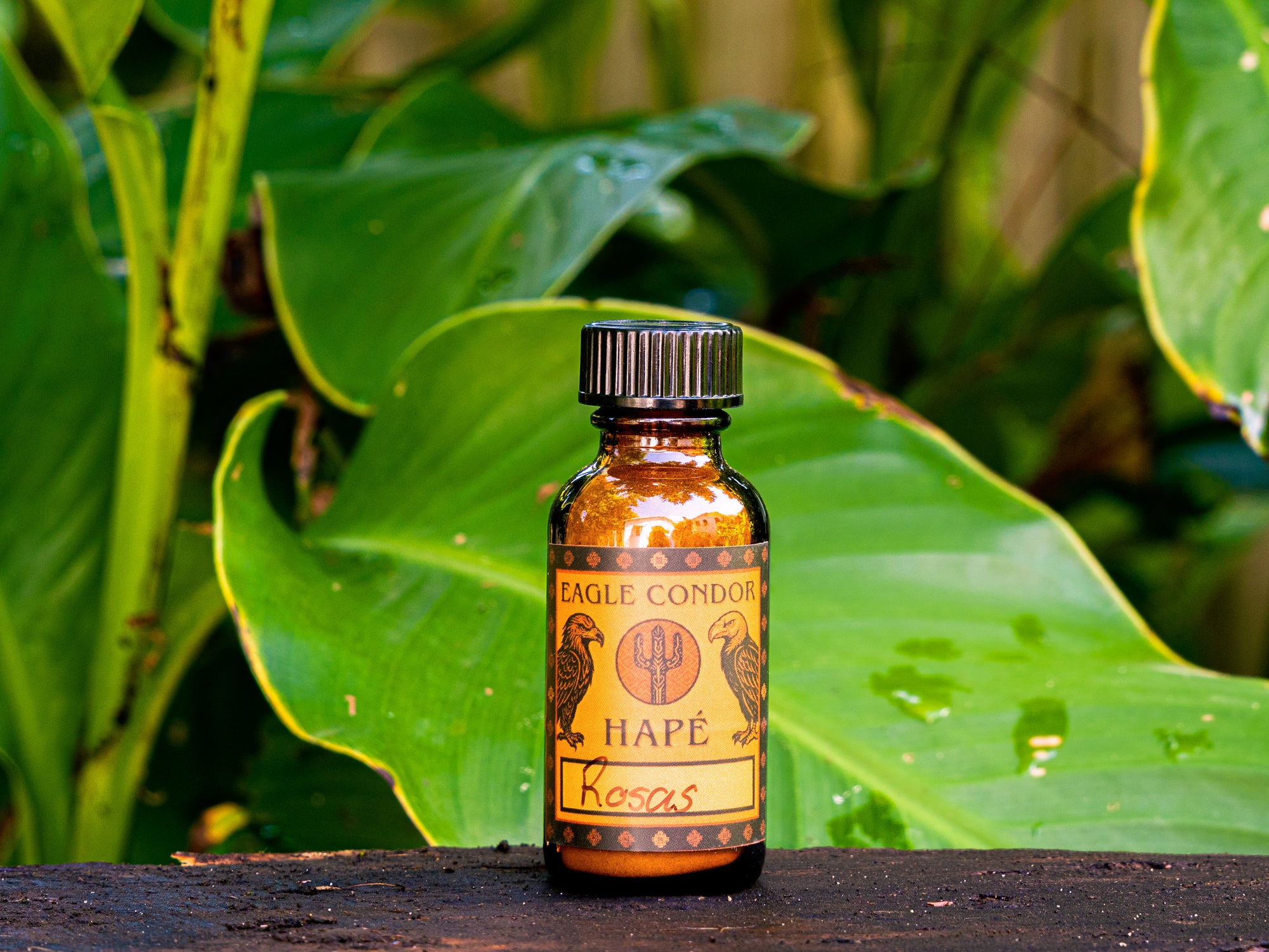 Bottle of Eagle Condor Hape Rosas against a natural background with green leaves.